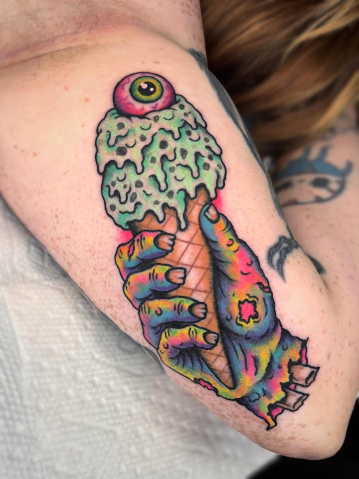 Zombie hand holding melting eyeball ice cream tattoo