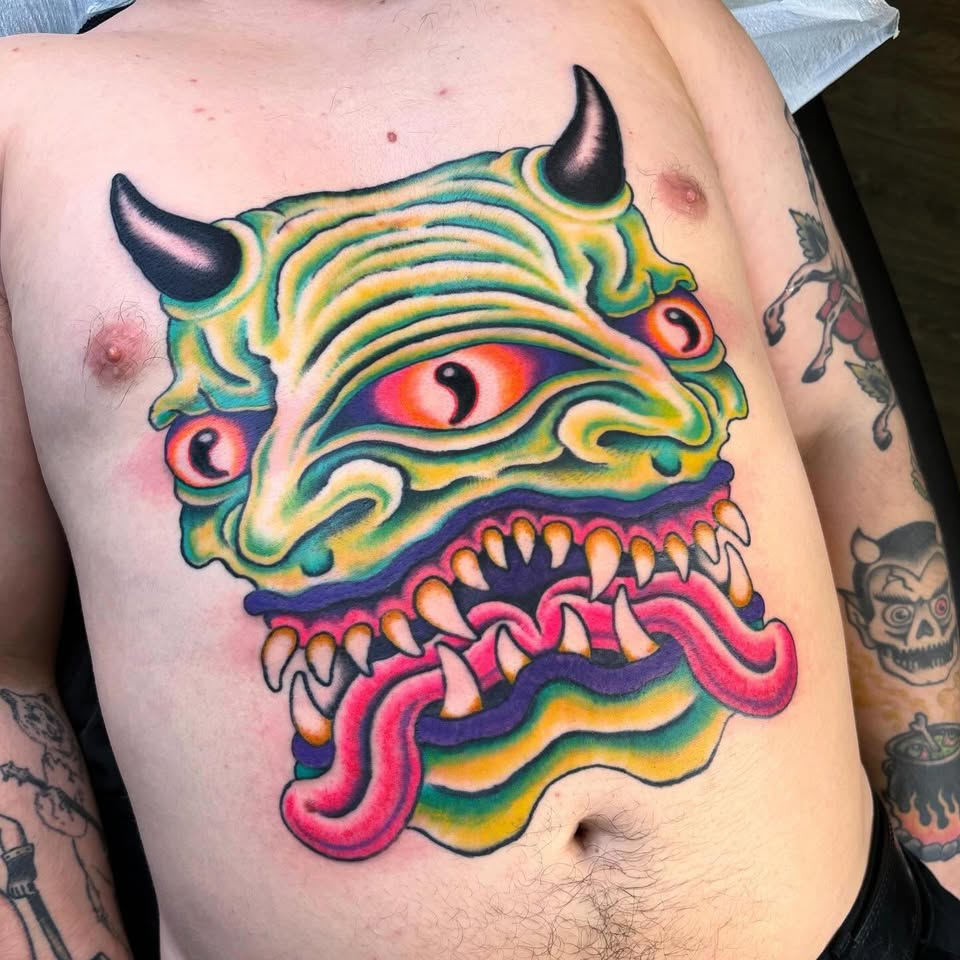 Three-eyed horned demon chest tattoo