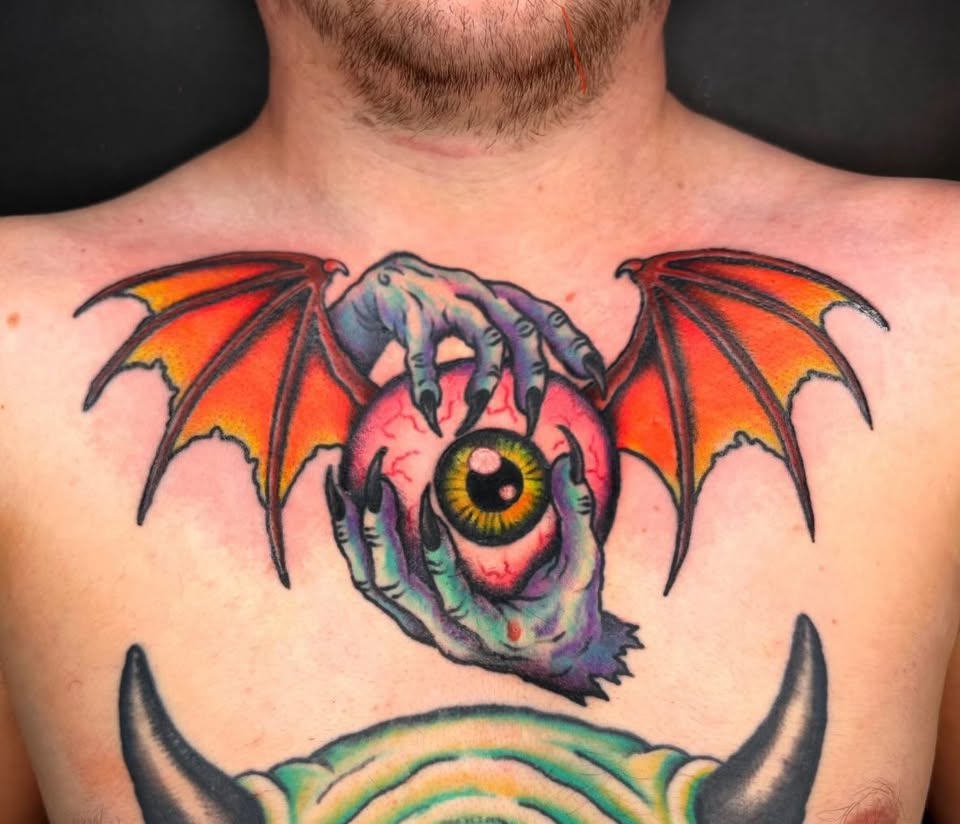 Winged eyeball with claws chest tattoo